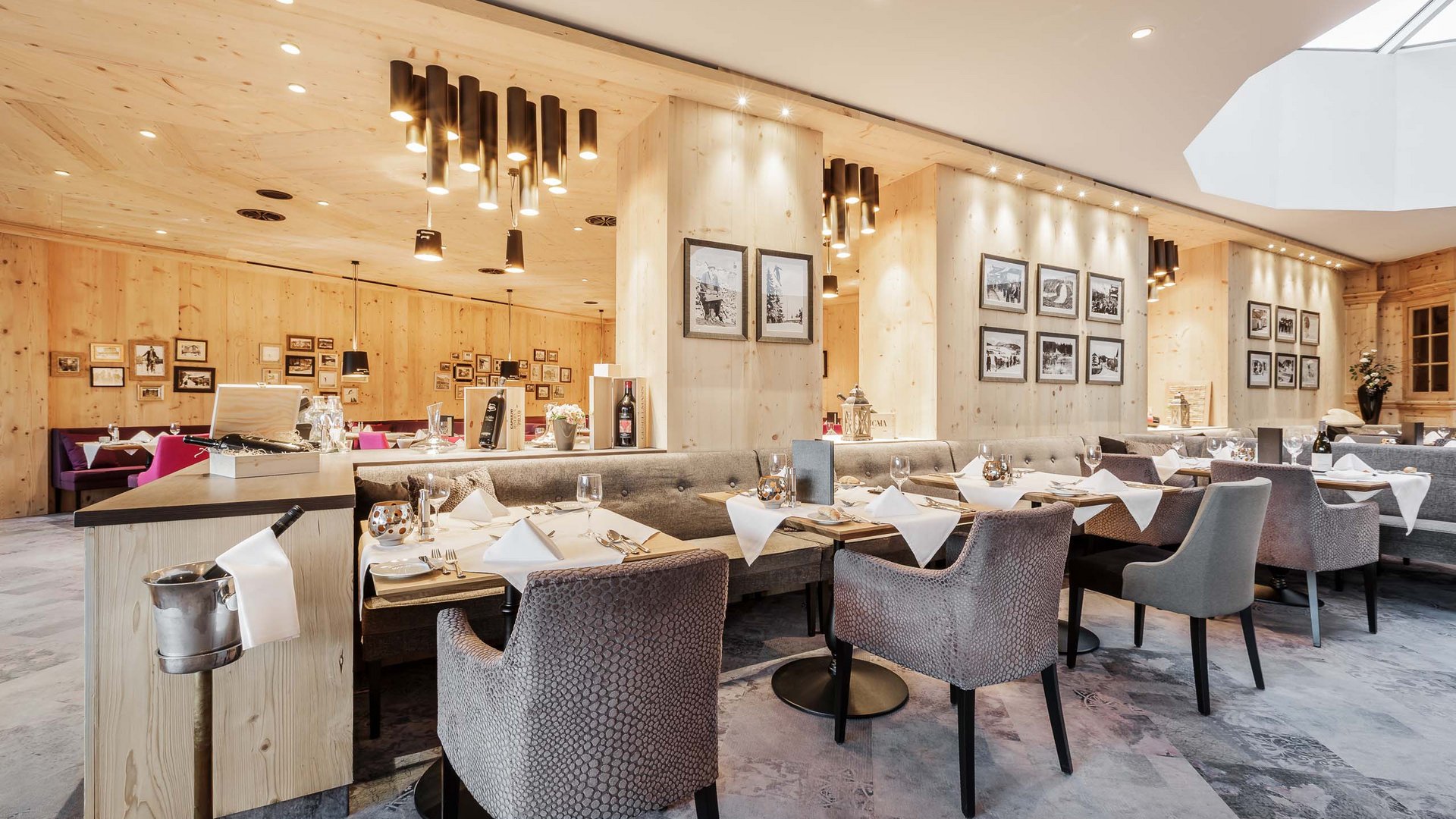 Gourmethotel in Seefeld: kulinarische Höhenflüge Hell eingerichteter Restaurantbereich mit Holzwänden und gedeckten Tischen